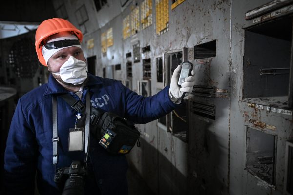 Photo: A visitor in protective clothing uses a dosimeter to take radiation readings on the control room panels of Reactor No. 4 of the Chornobyl Nuclear Power Plant on January 17, 2025. Nuclear plant workers continue to monitor the conditions of the reactors and carry out necessary tasks during the decommissioning process which began in August 2015. Credit: Justin Yau/ Sipa USA