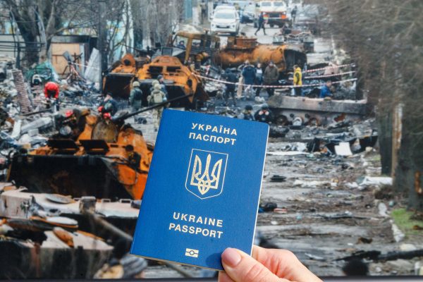 Photo: KYIV, UKRAINE - APRIL 25, 2024 - A man holds a foreign passport of a citizen of Ukraine against the photo of Vokzalna Street in Bucha, Kyiv Region, following the liberation of the city from Russian invaders, Kyiv, capital of Ukraine. Credit: Ukrinform/Ukrinform/Sipa USA via Reuters