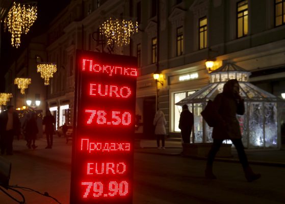 Photo: People walk past a board showing currency exchange rates of the euro against the ruble in a street decorated with festive illumination lights, part of the New Year and Christmas holidays celebration, in central Moscow, Russia, December 29, 2015. Credit: REUTERS/Maxim Zmeyev
