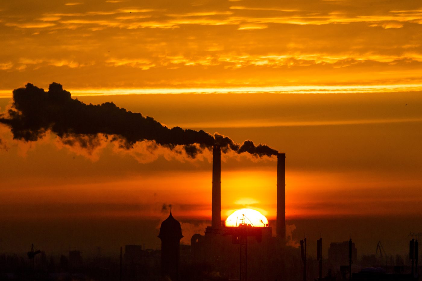 Photo: The sun rises behind the billowing chimneys of a power station in Berlin, November 27, 2013. Credit: REUTERS/Thomas Peter