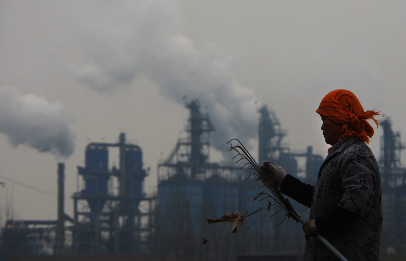 Photo: A Chinese farmer labors in a field as smoke is discharged from chimneys at a plant in Dezhou city, east China's Shandong province, 20 March 2016. China's carbon dioxide emission per 10,000 yuan (nearly $1,500) of GDP declined 4 percent in 2018, according to the National Bureau of Statistics (NBS). The country's total area of afforestation reached 7.07 million hectares last year, according to a communique on China's economic and social development in 2018 published by the NBS on Feb.28. Credit: Reuters.