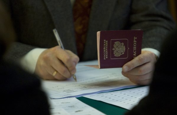 Photo: An assistant holds a passport of a Russian resident preparing to vote at the Russian embassy to Germany in Berlin December 2, 2007. Russians voted on Sunday in a parliamentary election widely viewed as a referendum on President Vladimir Putin and overshadowed by opposition accusations that pro-Kremlin forces enjoy an unfair advantage. Credit: REUTERS/Tobias Schwarz