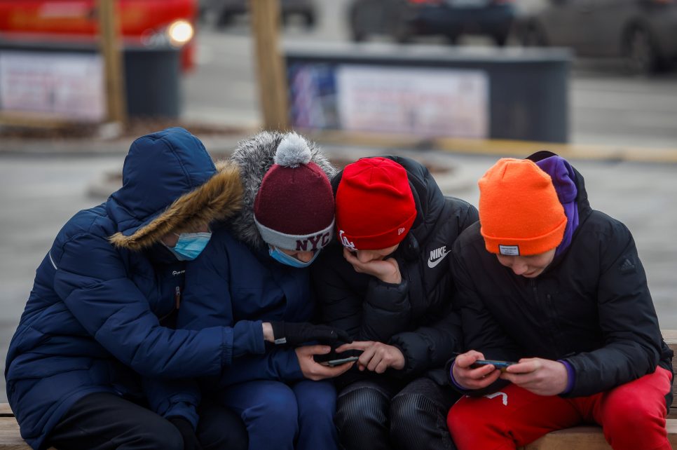 Photo: Boys use their mobile phones in a park in Moscow, Russia March 23, 2021. Credit: REUTERS/Maxim Shemetov