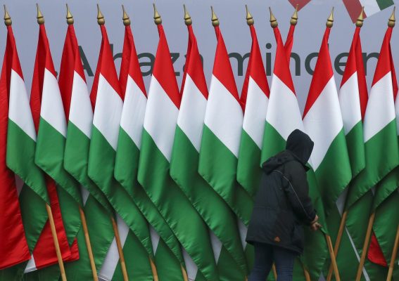 Photo: A man adjusts national flags before a pro-Orban rally during Hungary's National Day celebrations, which also commemorates the 1848 Hungarian Revolution against the Habsburg monarchy, in Budapest, Hungary, March 15, 2018. Credit: REUTERS/Marko Djurica