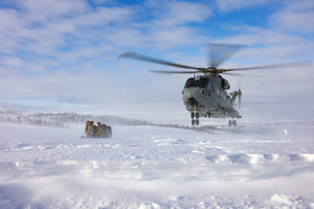 Photo: Merlin Helicopter landing in the snow picking up simulated supplies during exercise Joint Viking. Credit: NATO Flickr. https://flic.kr/p/2on7uR7.