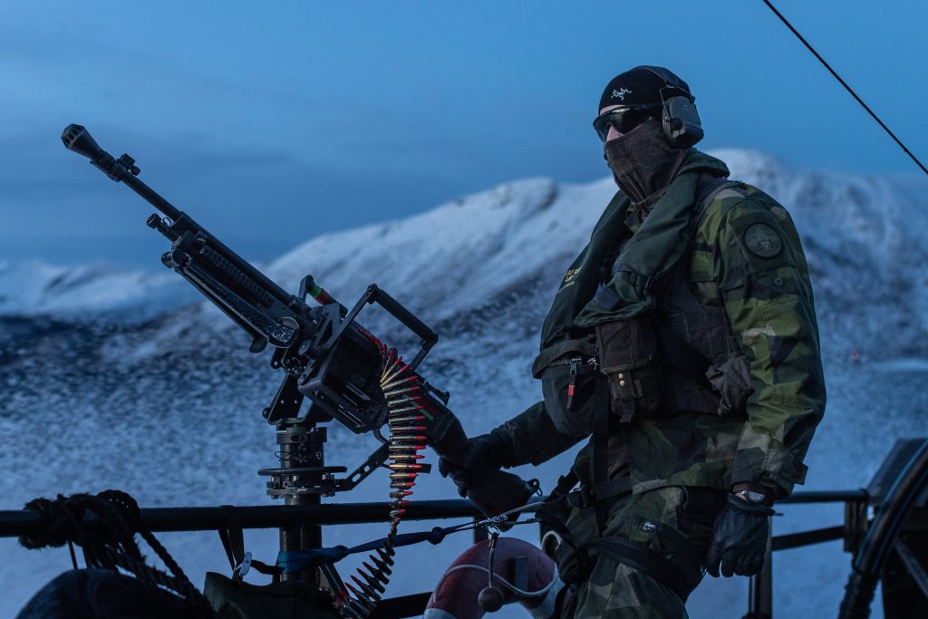 Photo: A Swedish Marine stands on the deck of a CB-90 fast assault boat as it cuts through the water near Tovik, Norway prior to Exercise Nordic Response 24. Credit: NATO Flickr. https://flic.kr/p/2pBKJWN.