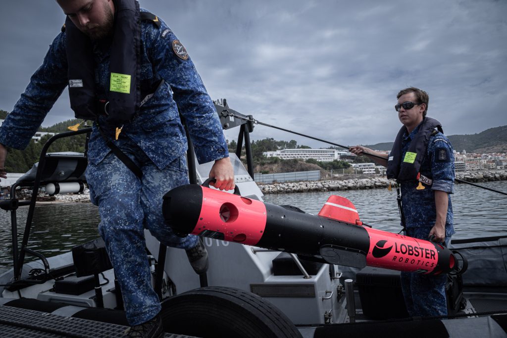 Royal Netherlands Navy representatives carry underwater drone during REPMUS 2025. Credit: NATO Flickr. https://flic.kr/p/2rwd83A.